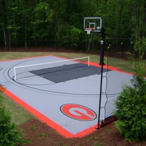 Outdoor multipurpose court with a basketball hoop, a volleyball net, fencing around the court and a Georgia Bulldogs logo.