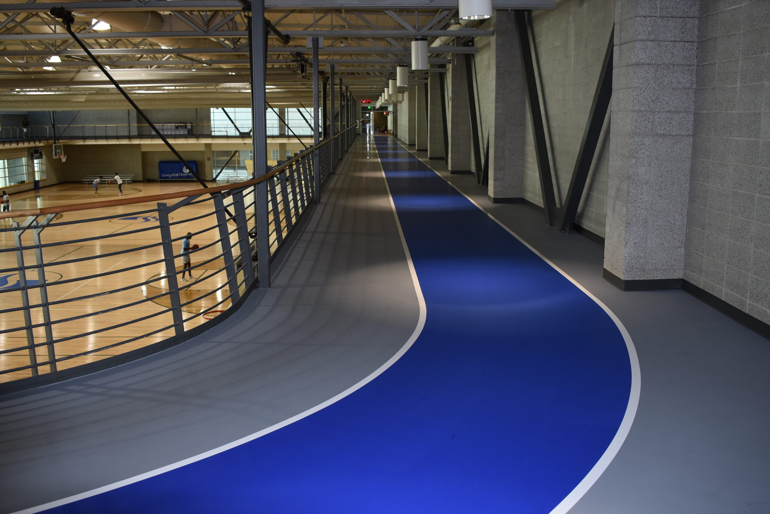 Blue and gray indoor track floor on the top floor of a gymnasium.