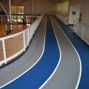 Blue and gray indoor running track on the second floor of a gymnasium.
