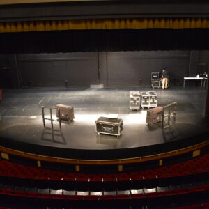 Auditorium stage flooring and stage being set up for a performance.