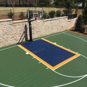 Outdoor residential court with green, yellow and blue court floor tiles.