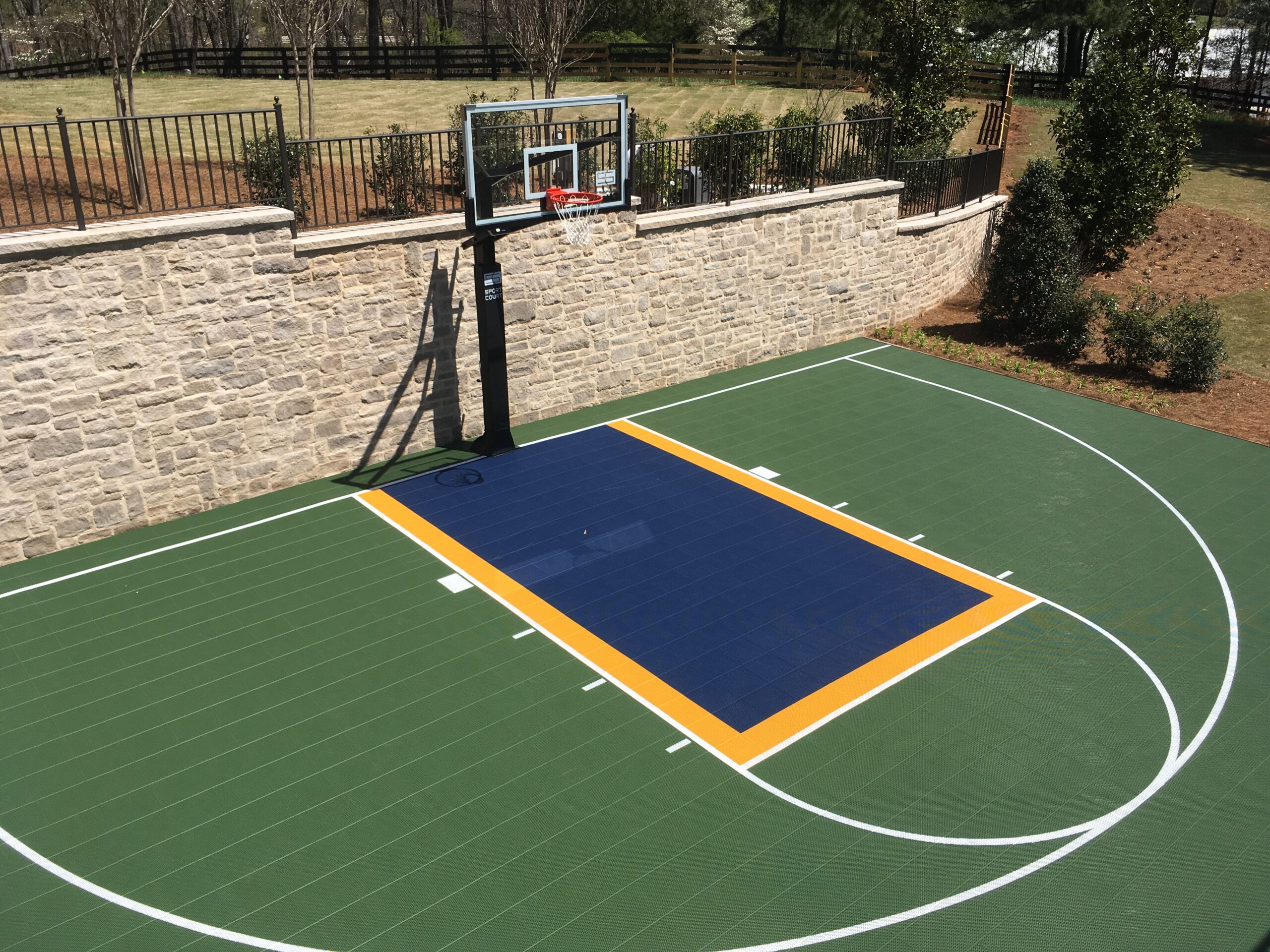 Outdoor residential court with green, yellow and blue court floor tiles.