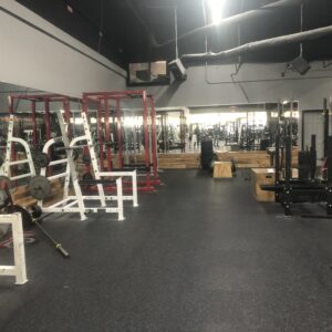 Indoor weight room with weights and gym flooring.