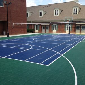 Outdoor multipurpose court with basketball hoops and a volleyball net.