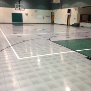 indoor sports gymnasium with gray and green tile flooring.