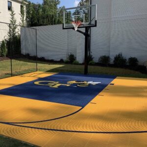 Outdoor residential basketball court with outdoor tiles and a Georgia Tech logo.