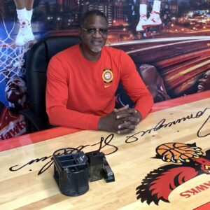 Dominique Wilkins, president of CBA Sports, sitting at his office desk.
