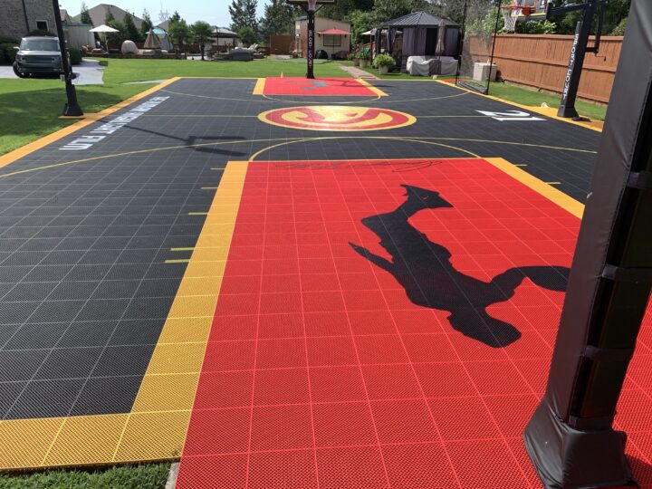 Outdoor residential basketball court with multiple hoops and the Atlanta Hawks branding.