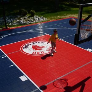 kid shooting a basketball on a backyard basketball court with Boston Red Sox logo
